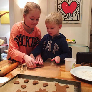 Little girl and boy cutting cookie dough shapes